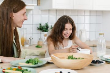 Father and daughter sharing a joyful breakfast at home in the kitchen.